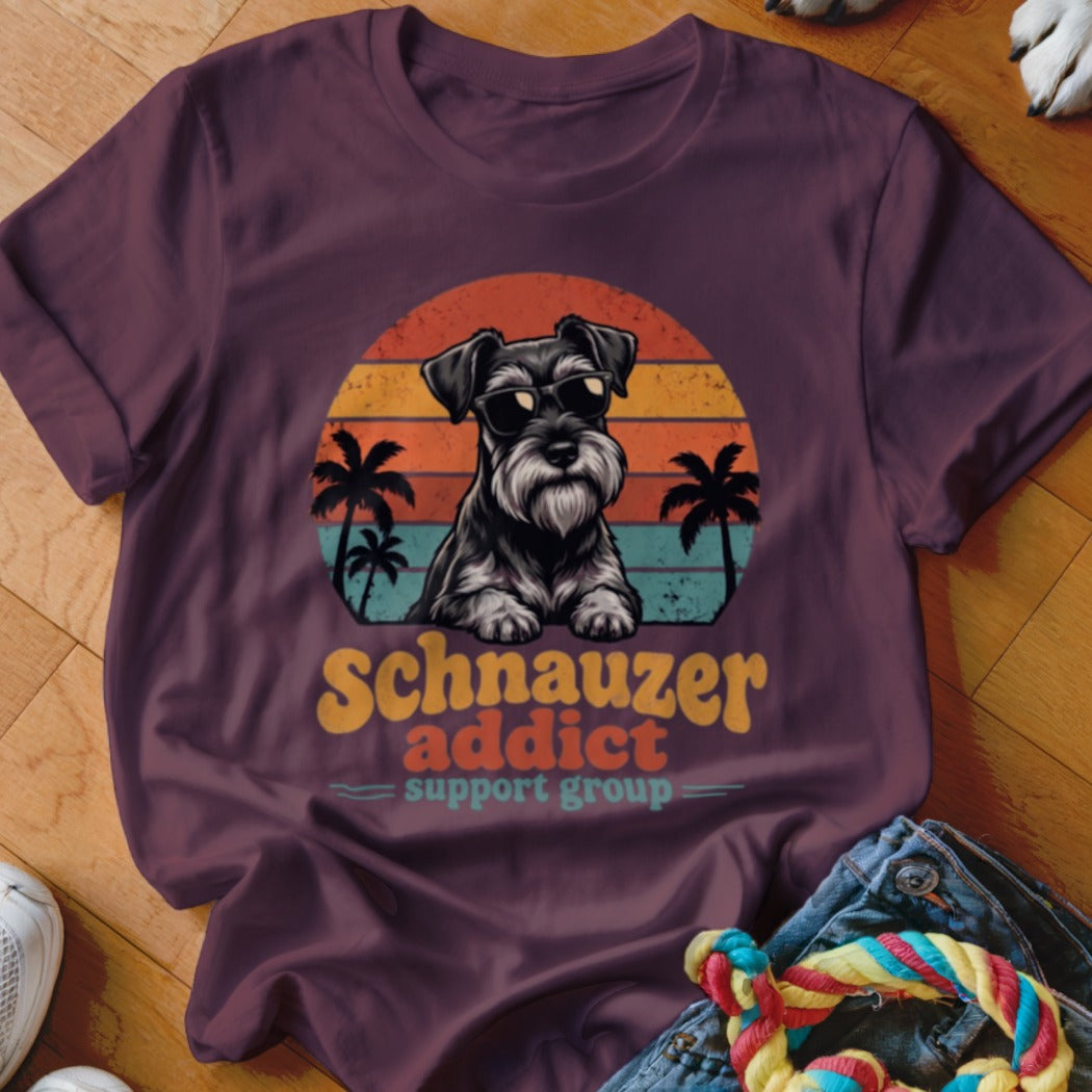 Maroon t-shirt featuring a retro graphic of a Schnauzer wearing sunglasses inside a sunset with palm trees.