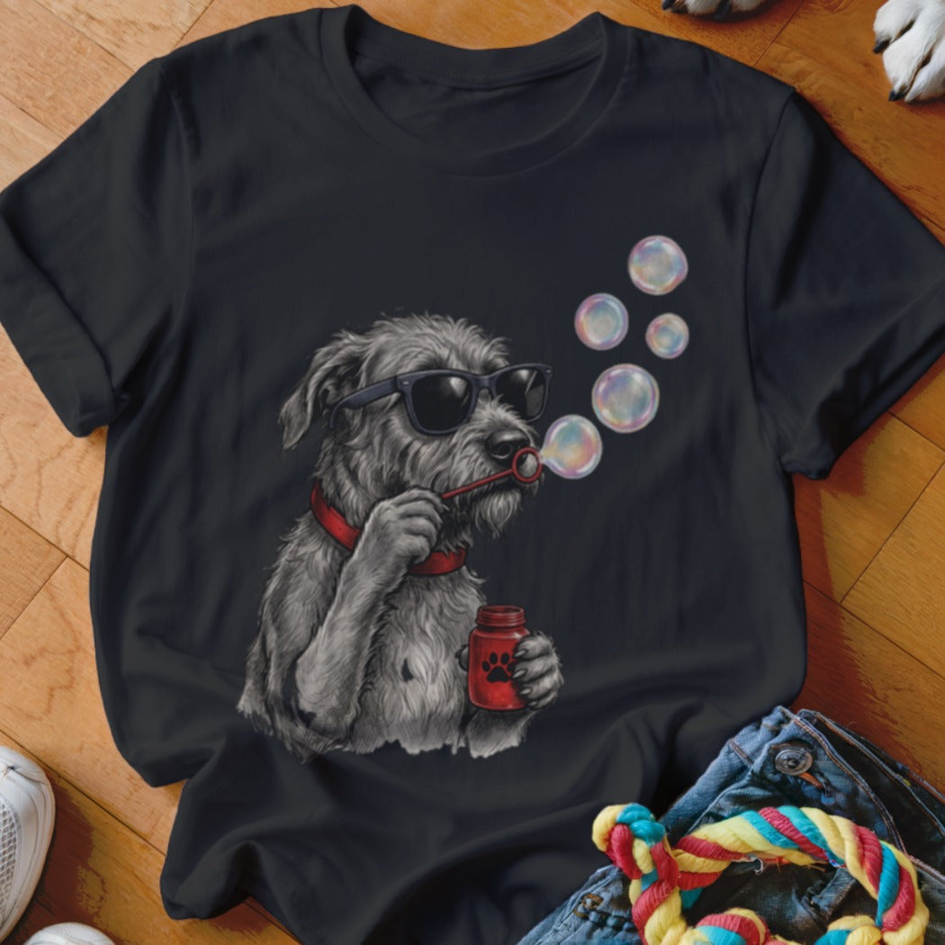 A black t-shirt featuring a graphic of a scruffy grey dog wearing sunglasses while blowing bubbles.