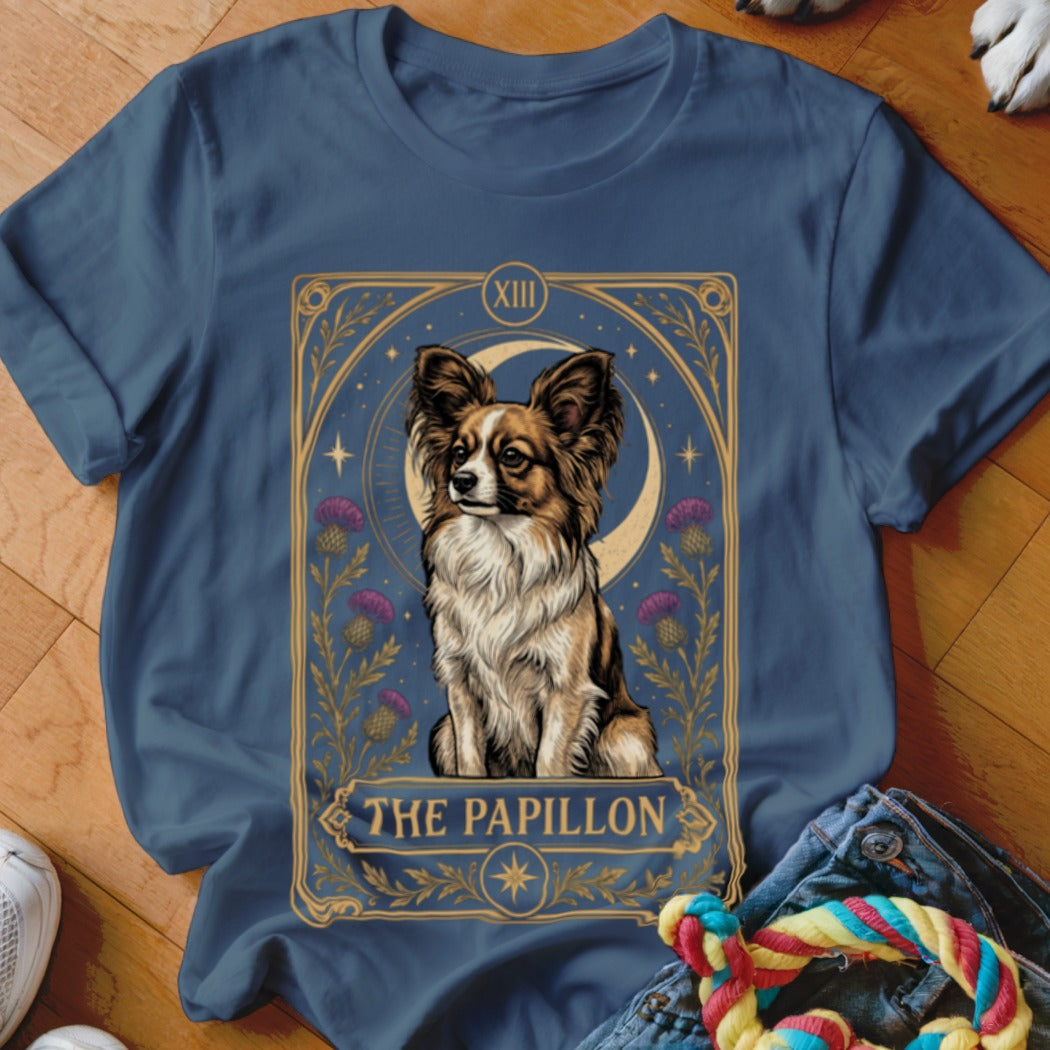 Blue t-shirt featuring a tarot card style illustration of a Papillon dog surrounded by thistle flowers.