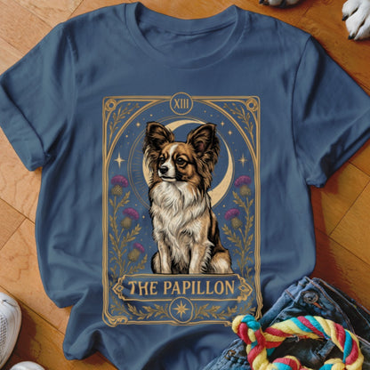 Blue t-shirt featuring a tarot card style illustration of a Papillon dog surrounded by thistle flowers.