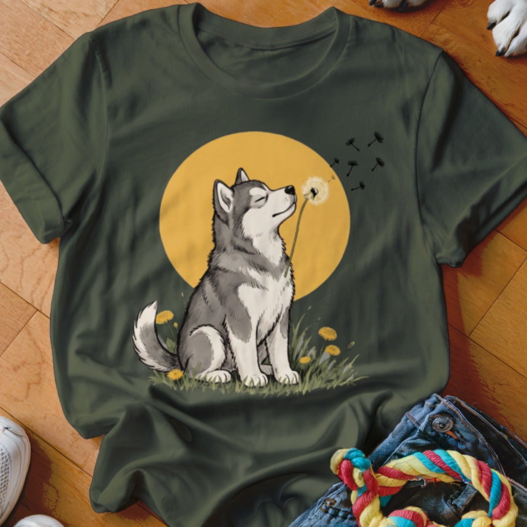 Dark green t-shirt featuring an illustration of a husky blowing dandelion seeds in front of a yellow moon.