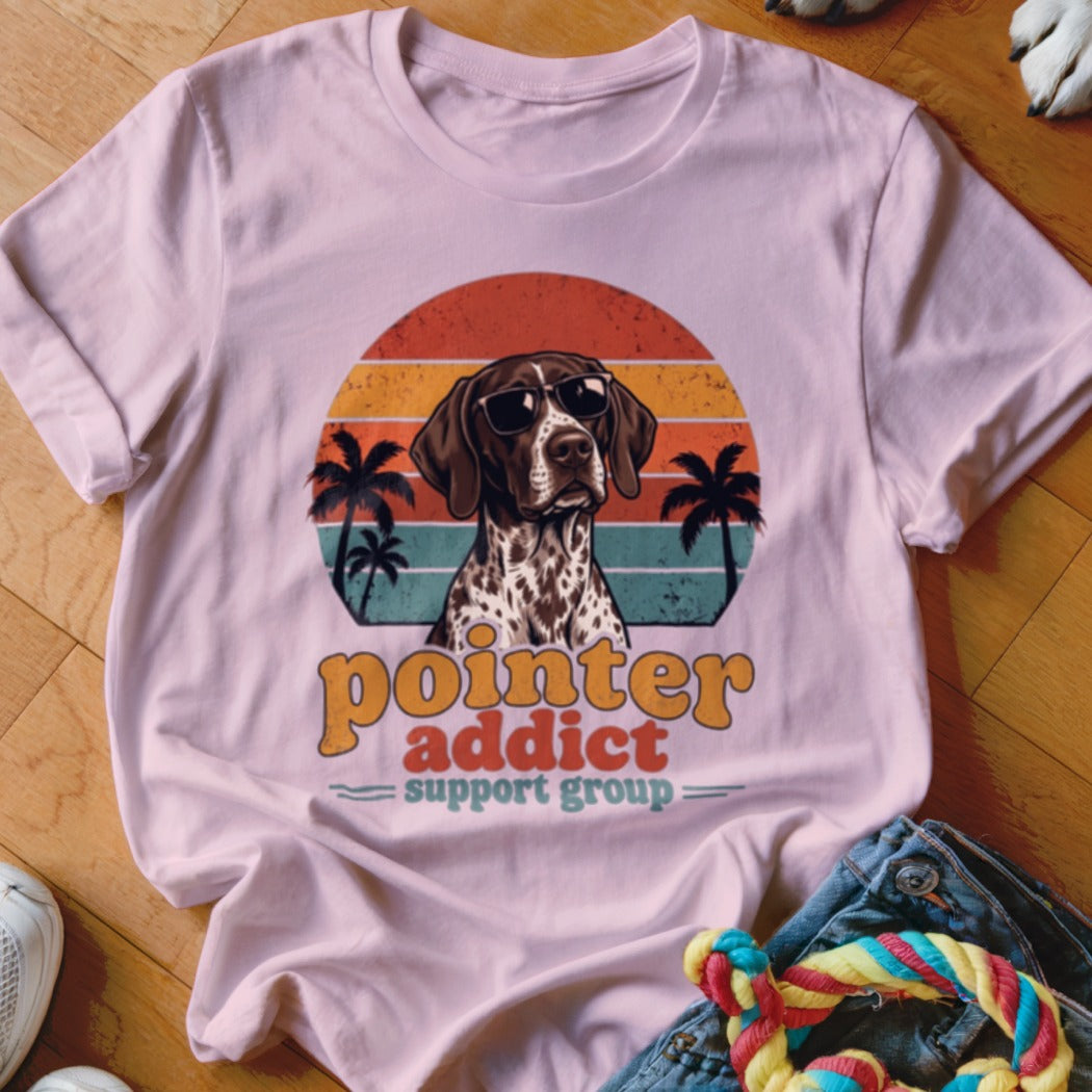 Light pink t-shirt featuring a retro graphic of a German Shorthaired Pointer wearing sunglasses with sunset and palm tree background.