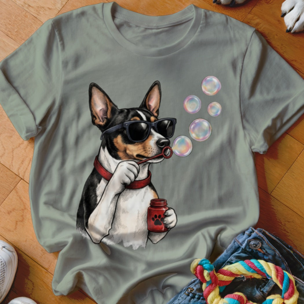 A sage green crewneck t-shirt featuring a graphic of a dog wearing sunglasses and blowing bubbles.