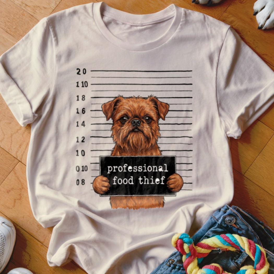 Brown dog with mugshot sign reading "professional food thief".
