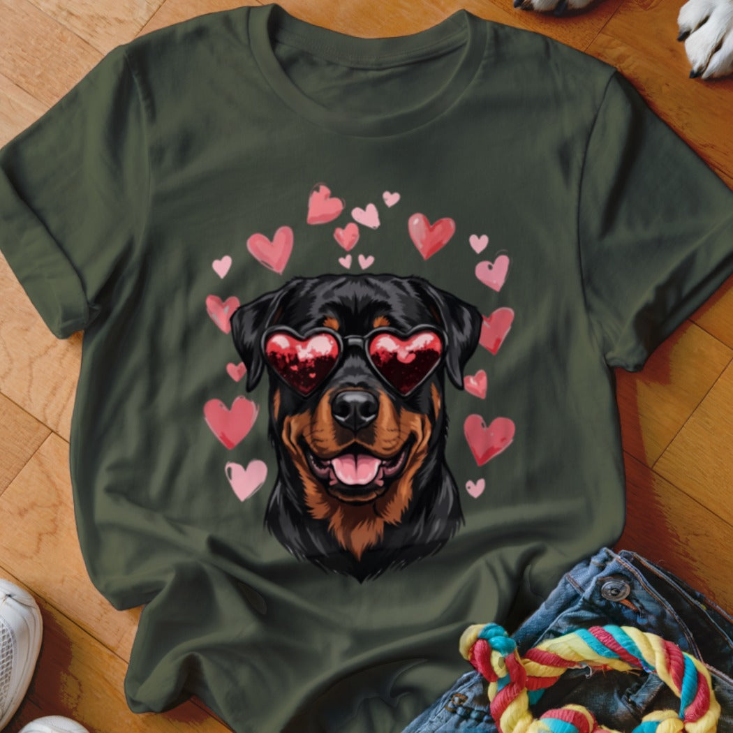 Dark green t-shirt featuring a Rottweiler wearing heart-shaped sunglasses, surrounded by floating pink hearts.