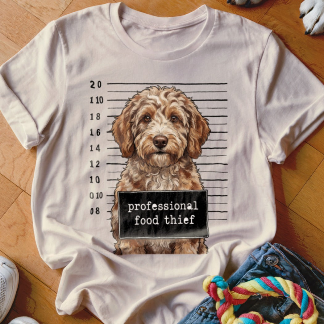 Dog mugshot graphic with text "professional food thief" on a white t-shirt.