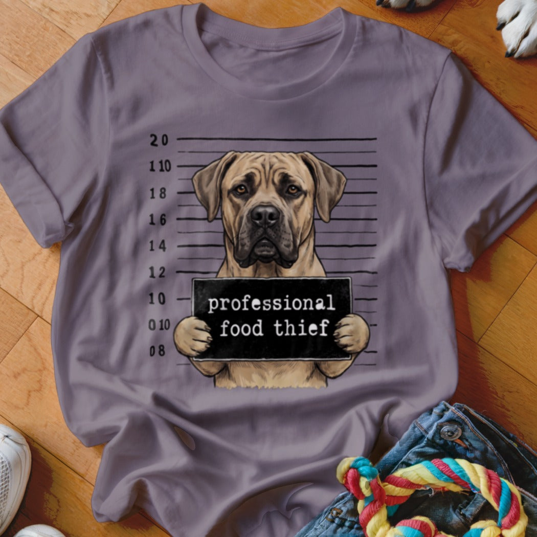 T-shirt graphic of a dog holding a "professional food thief" sign in a mugshot.