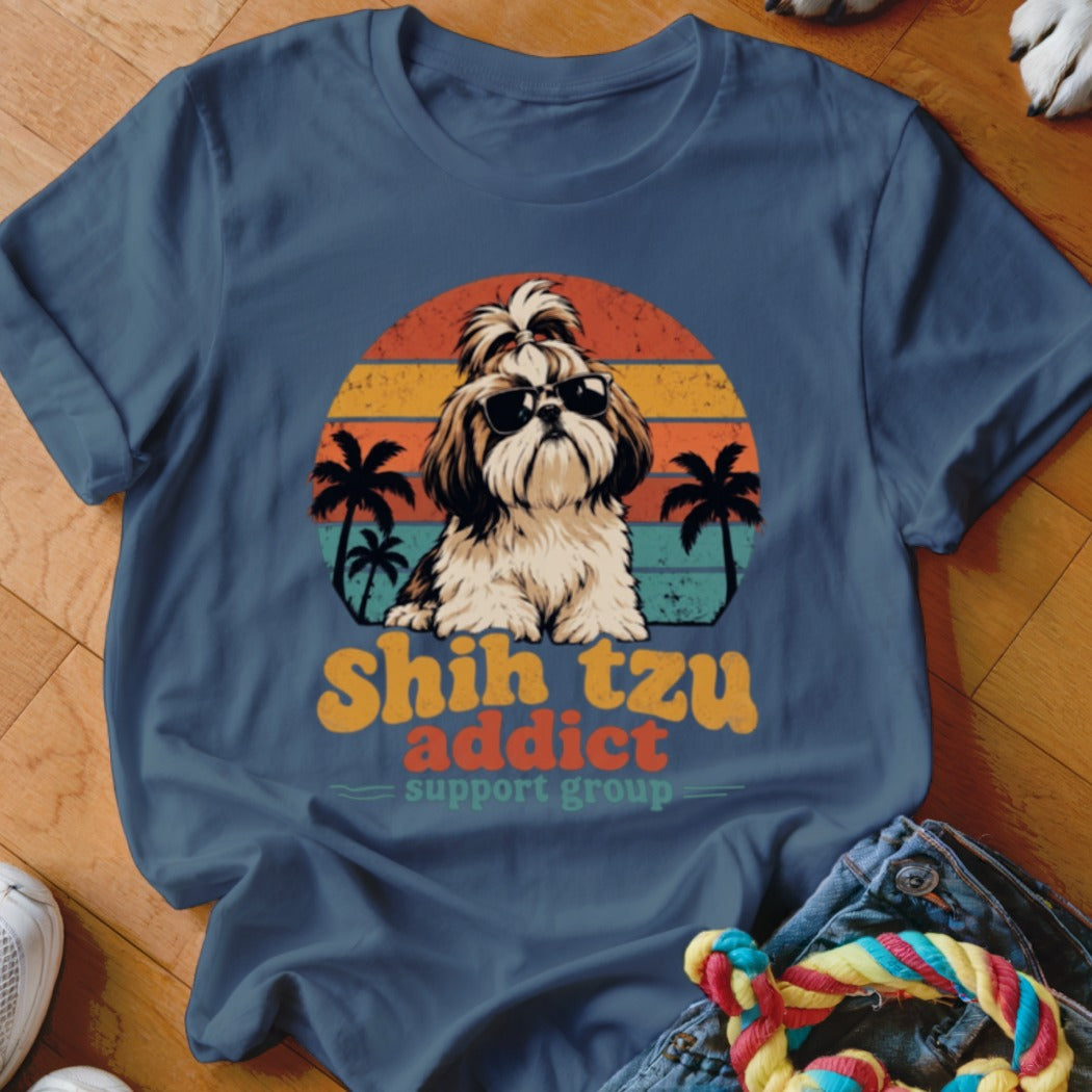 Blue t-shirt featuring a graphic of a Shih Tzu wearing sunglasses against a sunset and palm tree background.