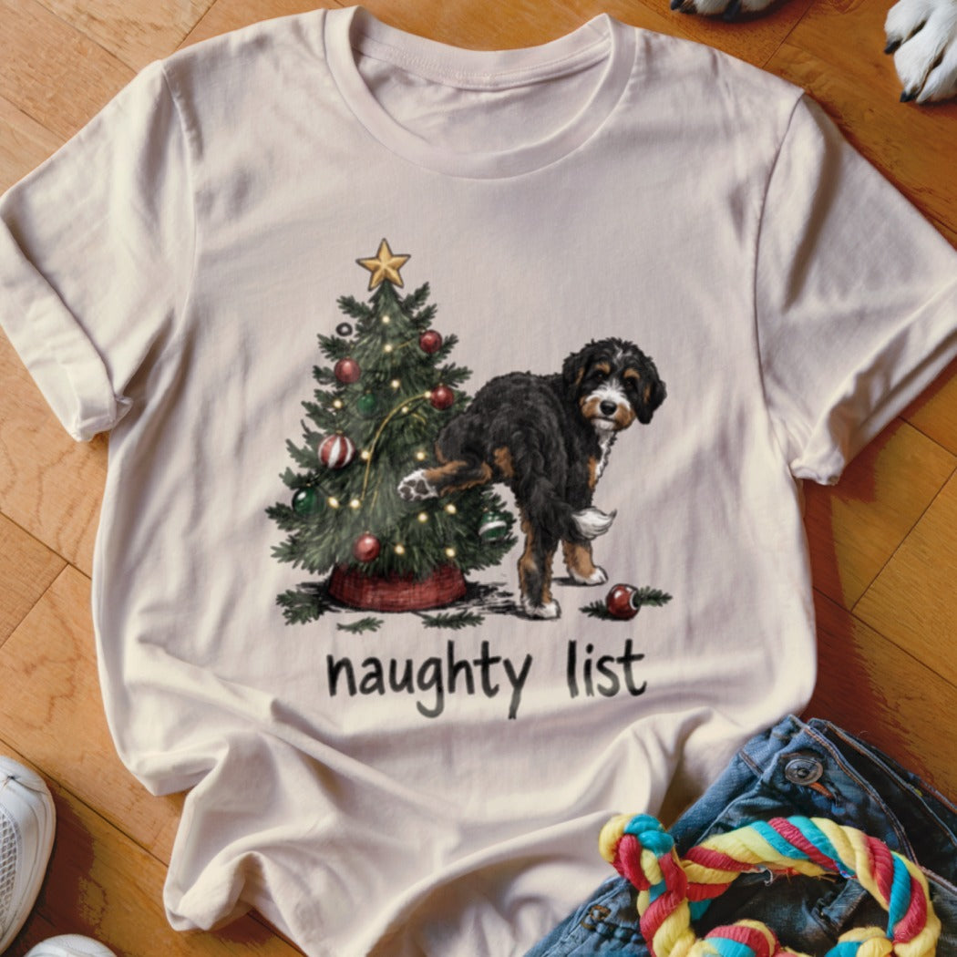 Bernese Mountain Dog near Christmas tree with text "naughty list"