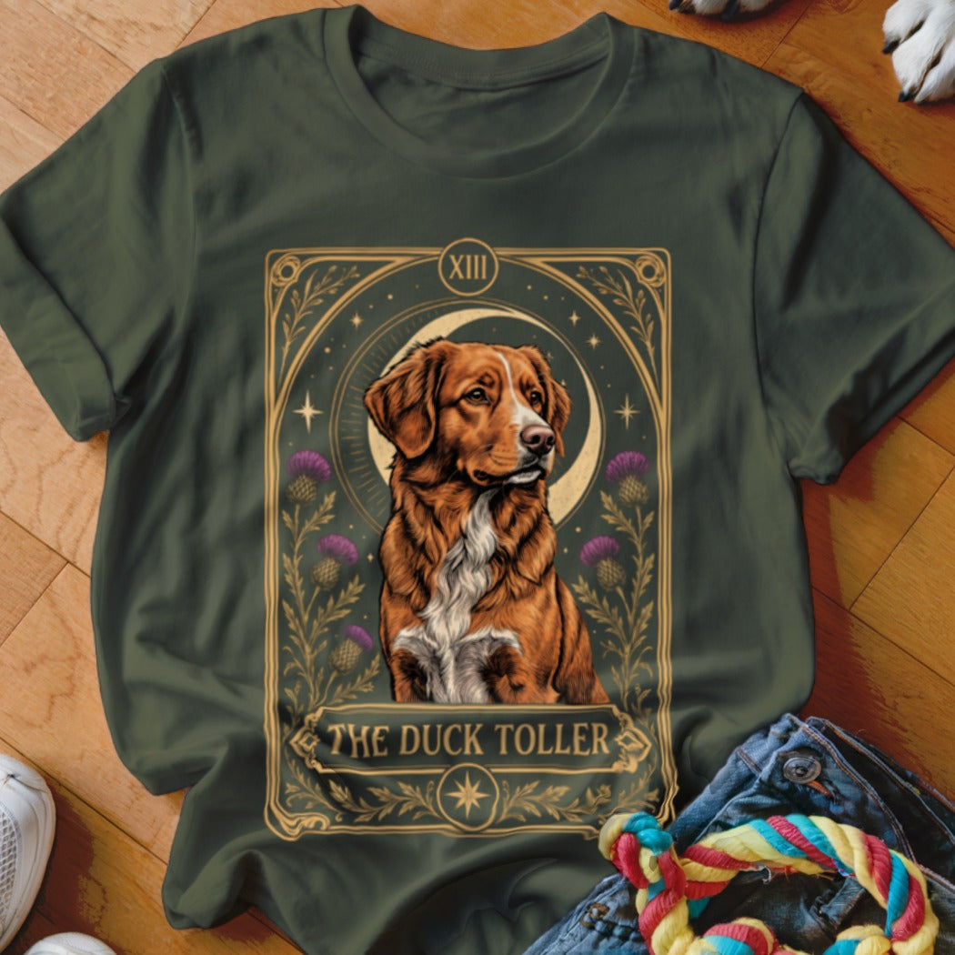 Dark green t-shirt featuring a tarot card graphic of a duck tolling retriever with thistles and the text The Duck Toller.