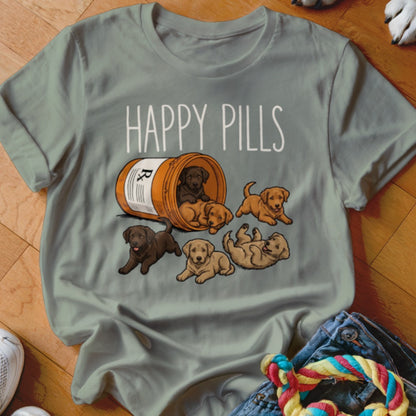 Shirt with "HAPPY PILLS" text and illustration of Labrador puppies spilling from a pill bottle.