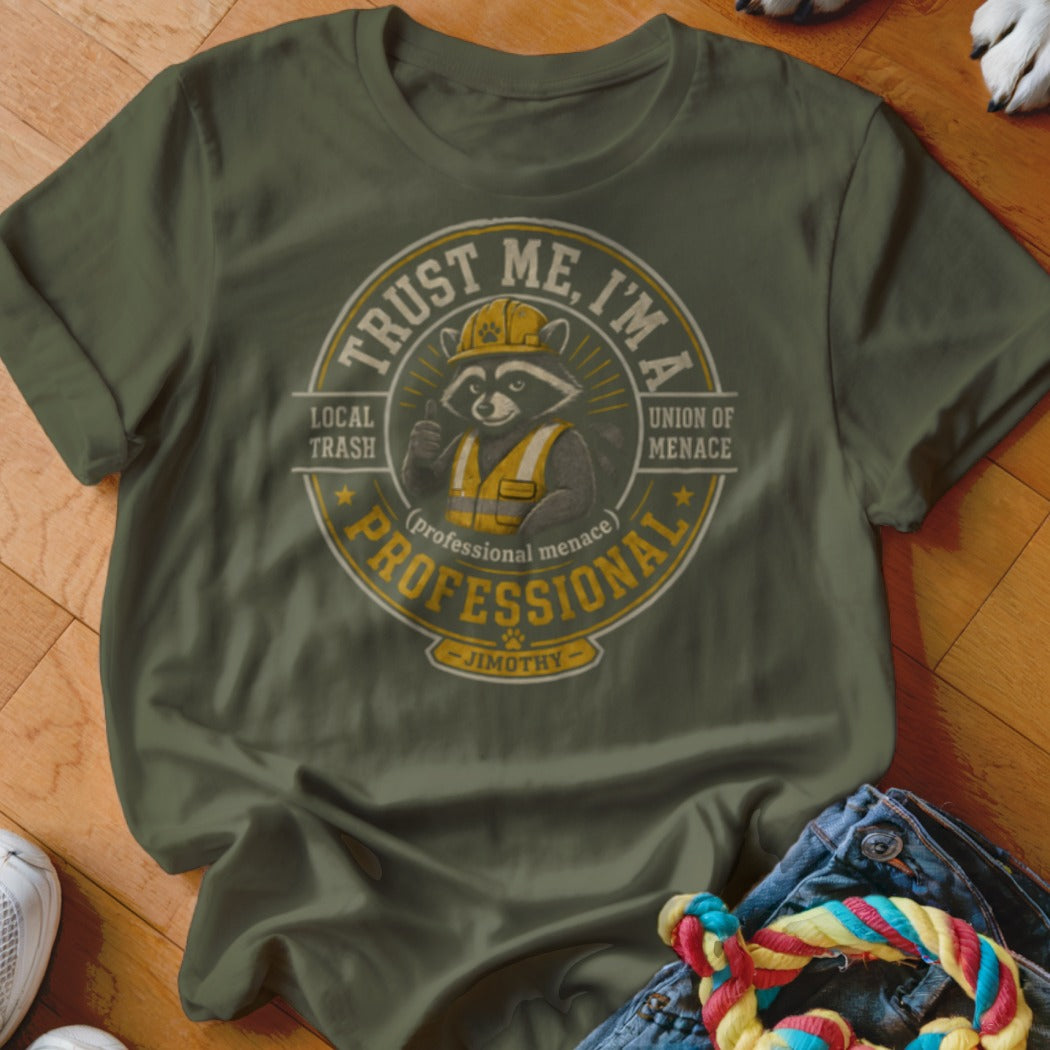 Olive green t-shirt with a circular graphic featuring a raccoon wearing a hard hat and vest, "Trust Me, I'm A Professional" text.