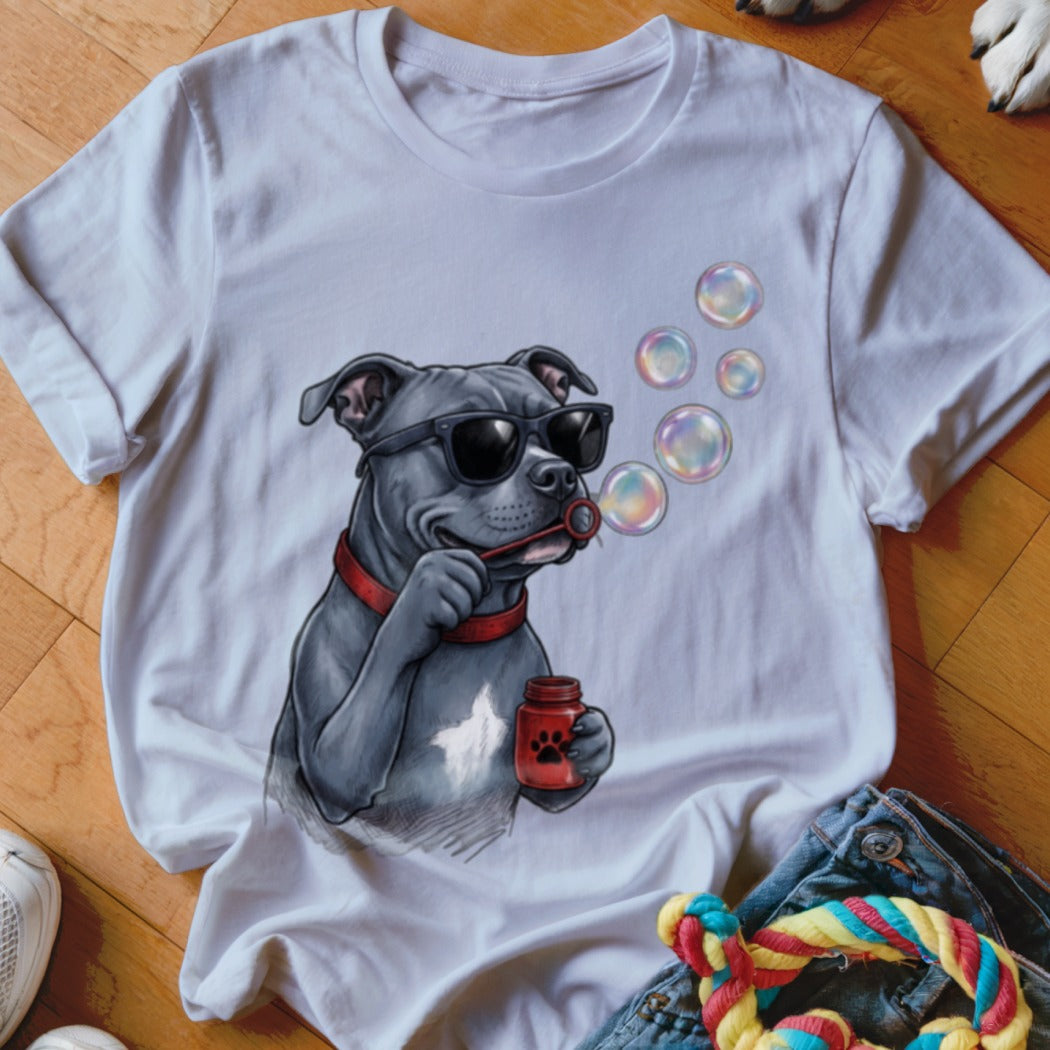 A white t-shirt featuring a graphic of a grey dog wearing sunglasses and blowing soap bubbles.