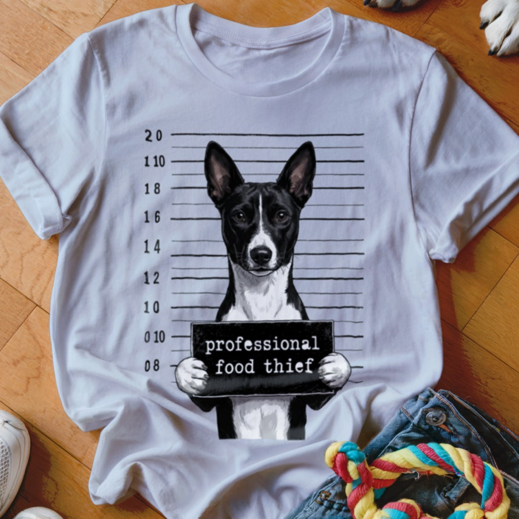 Dog wearing a mugshot sign that reads "professional food thief."