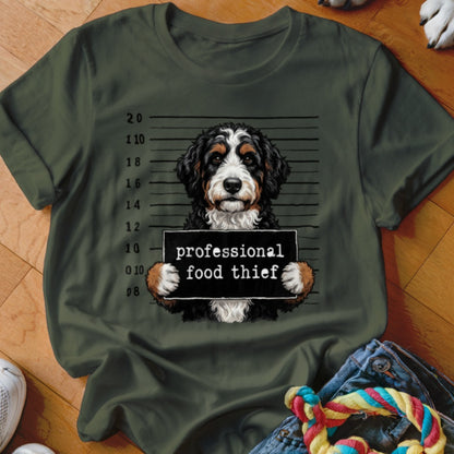 Bernese Mountain Dog mugshot with "professional food thief" sign.