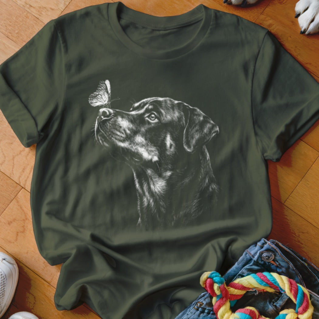Dark green crewneck t-shirt featuring a white sketch graphic of a Rottweiler looking at a butterfly.