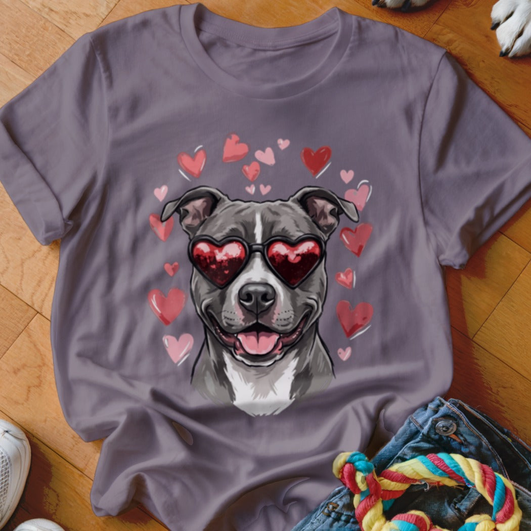A purple t-shirt featuring a graphic of a pit bull wearing heart-shaped sunglasses surrounded by pink hearts.