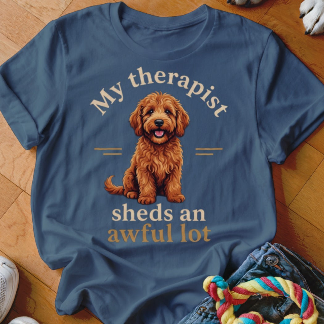Blue t-shirt with a goldendoodle illustration and text "My therapist sheds an awful lot".