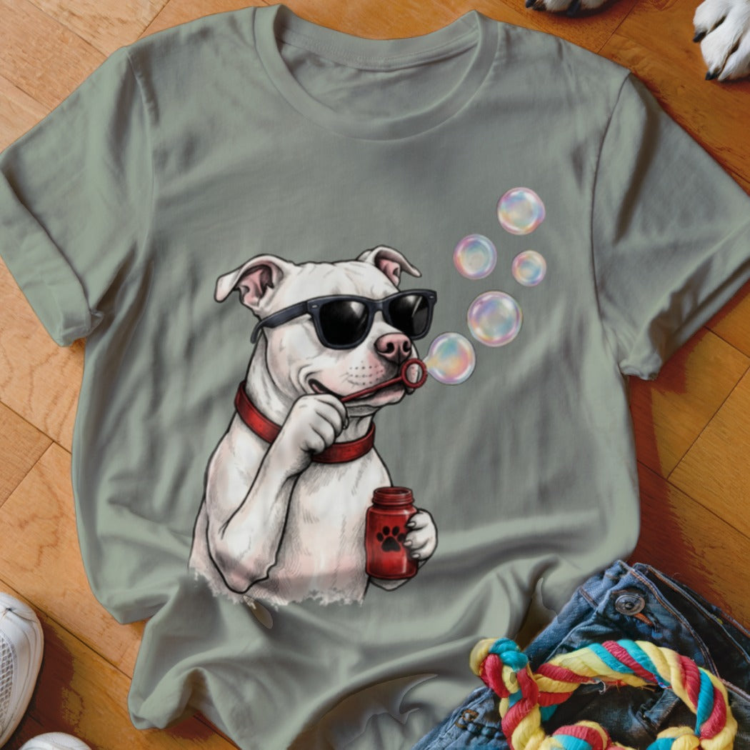 Sage green t-shirt featuring a graphic of a white pit bull wearing sunglasses and blowing soap bubbles.