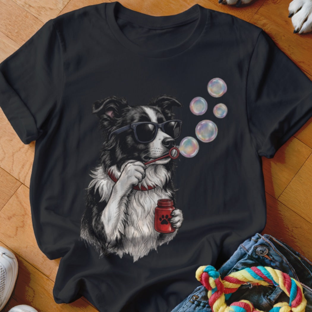 Black t-shirt featuring an illustration of a black and white dog wearing sunglasses and blowing soap bubbles.