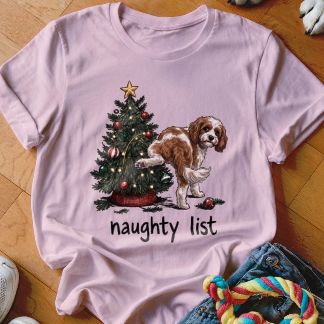 A brown and white dog pees on a Christmas tree with the text "naughty list".
