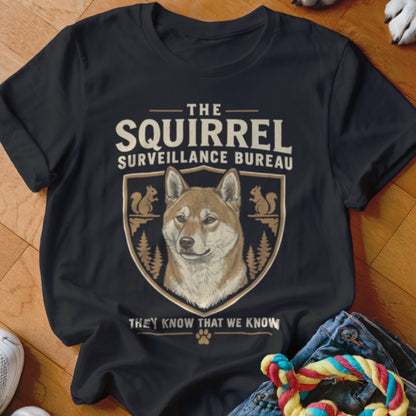 Black t-shirt featuring a Shiba Inu graphic with the text The Squirrel Surveillance Bureau.