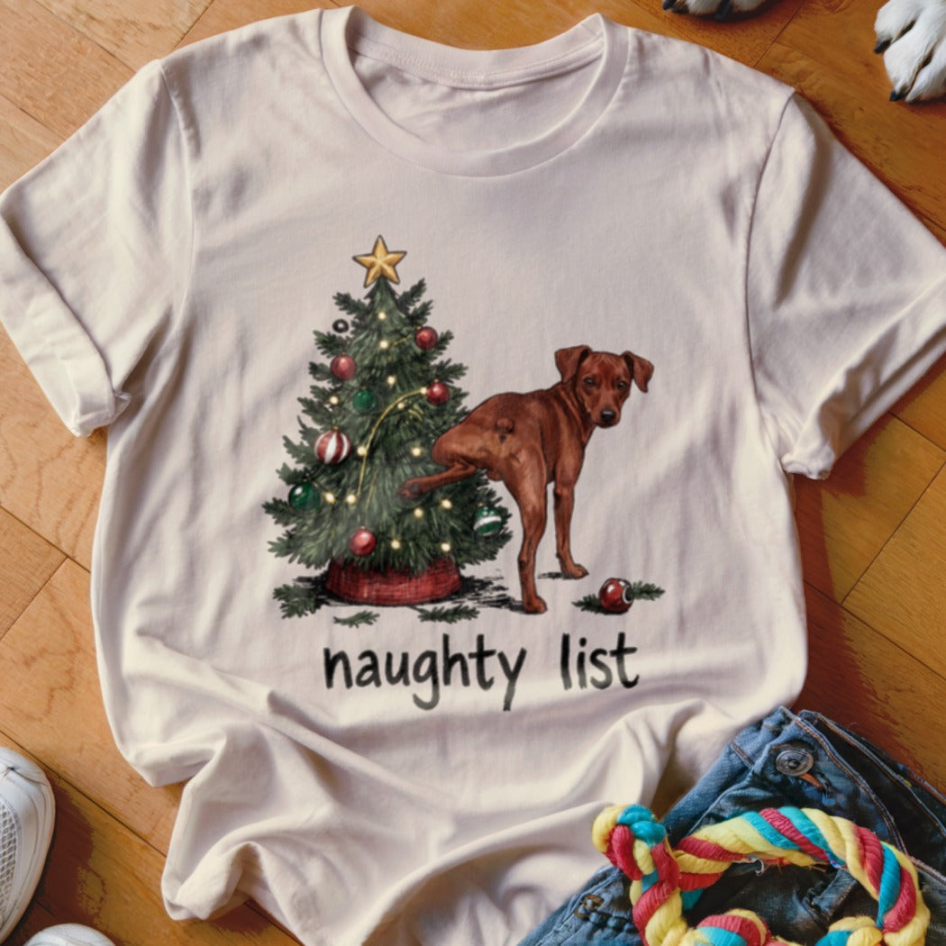 T-shirt with a brown dog near a Christmas tree and the words "naughty list".