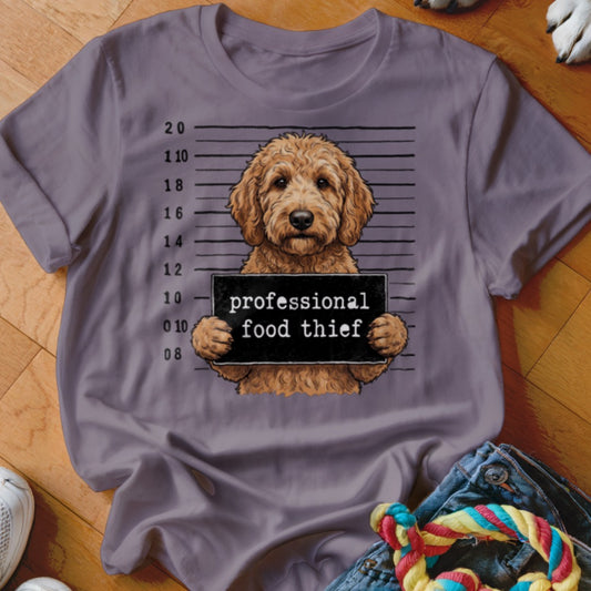 T-shirt with cartoon doodle dog holding a "professional food thief" sign in mugshot style.