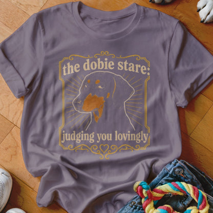 Purple t-shirt with "the dobie stare: judging you lovingly" and a Doberman outline.