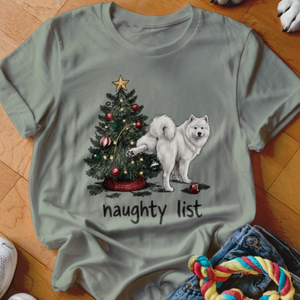 Olive green t-shirt featuring a graphic of a white dog peeing on a Christmas tree with the text naughty list.