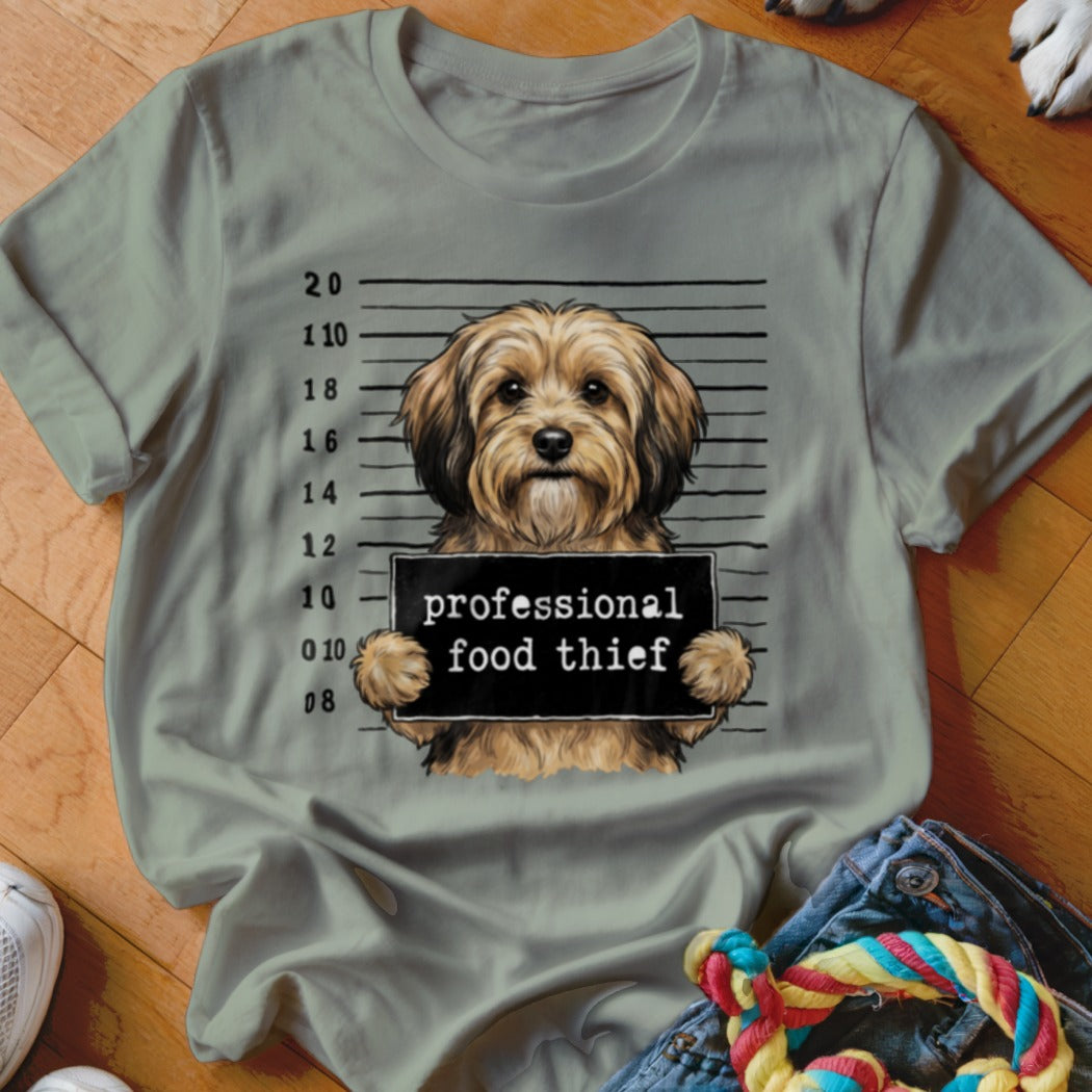 Dog mugshot with sign reading "professional food thief".
