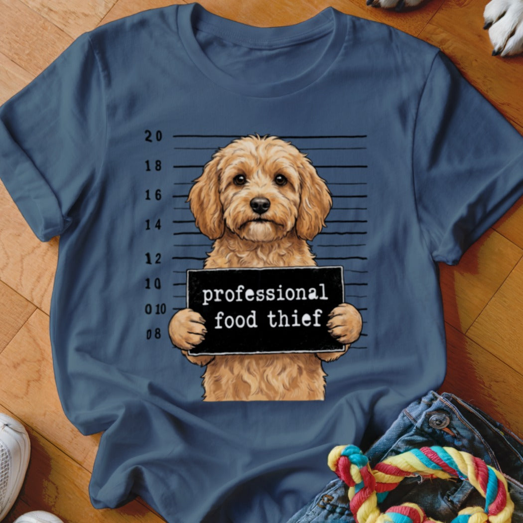Goldendoodle dog in mugshot holding "professional food thief" sign.