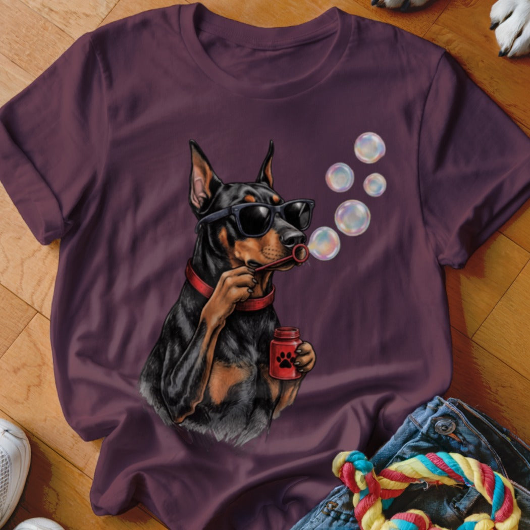 Plum t-shirt featuring a graphic of a Doberman Pinscher wearing sunglasses and blowing bubbles.