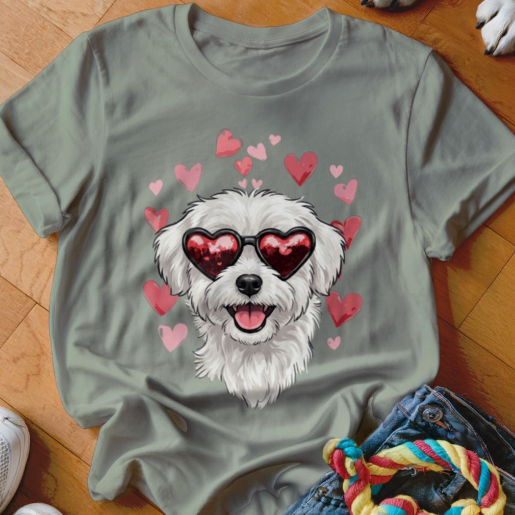 Sage green t-shirt featuring a graphic of a white fluffy dog wearing heart sunglasses surrounded by pink hearts.