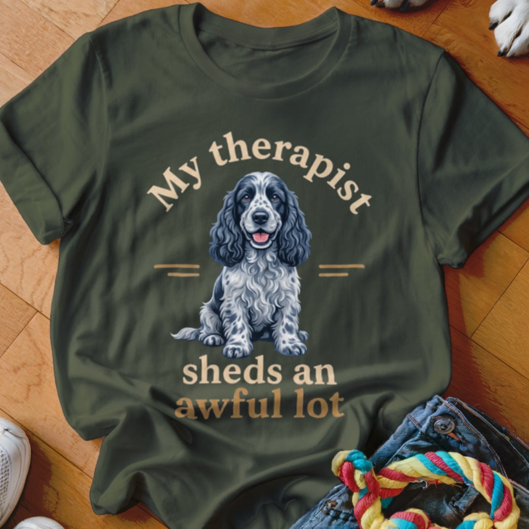 Olive t-shirt with a blue merle Cocker Spaniel and text "My therapist sheds an awful lot".