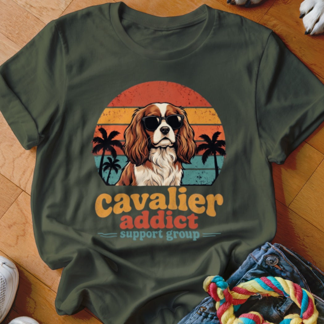 Dark green t-shirt with a retro graphic of a Cavalier King Charles Spaniel wearing sunglasses against a sunset.