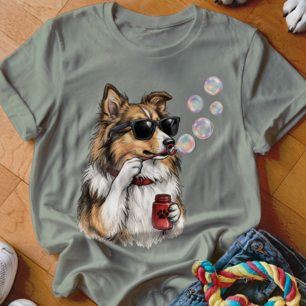 Sage green t-shirt featuring a graphic of a dog wearing sunglasses and blowing bubbles.