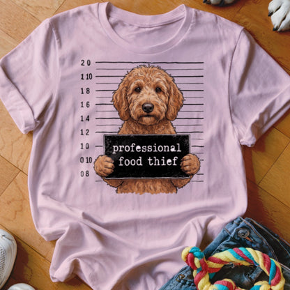 Pink t-shirt with a dog holding a sign that says "professional food thief."