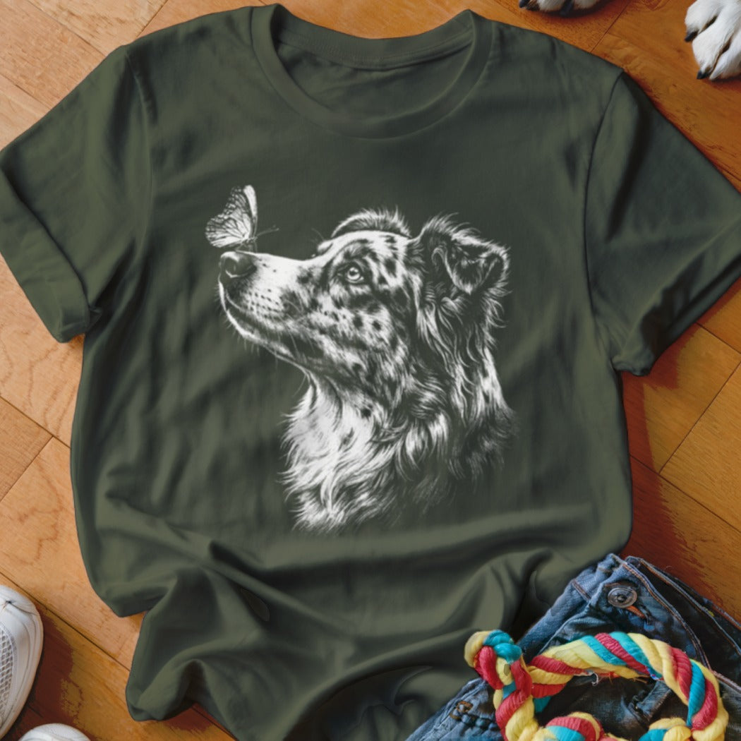 Dark green t-shirt featuring a white sketch of an Australian Shepherd looking at a butterfly.