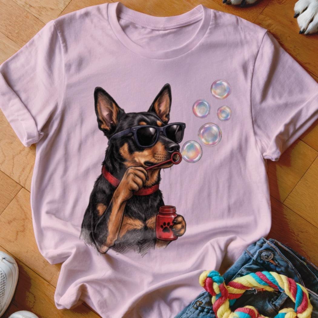 A light pink t-shirt featuring a graphic of a black dog wearing sunglasses and blowing bubbles.