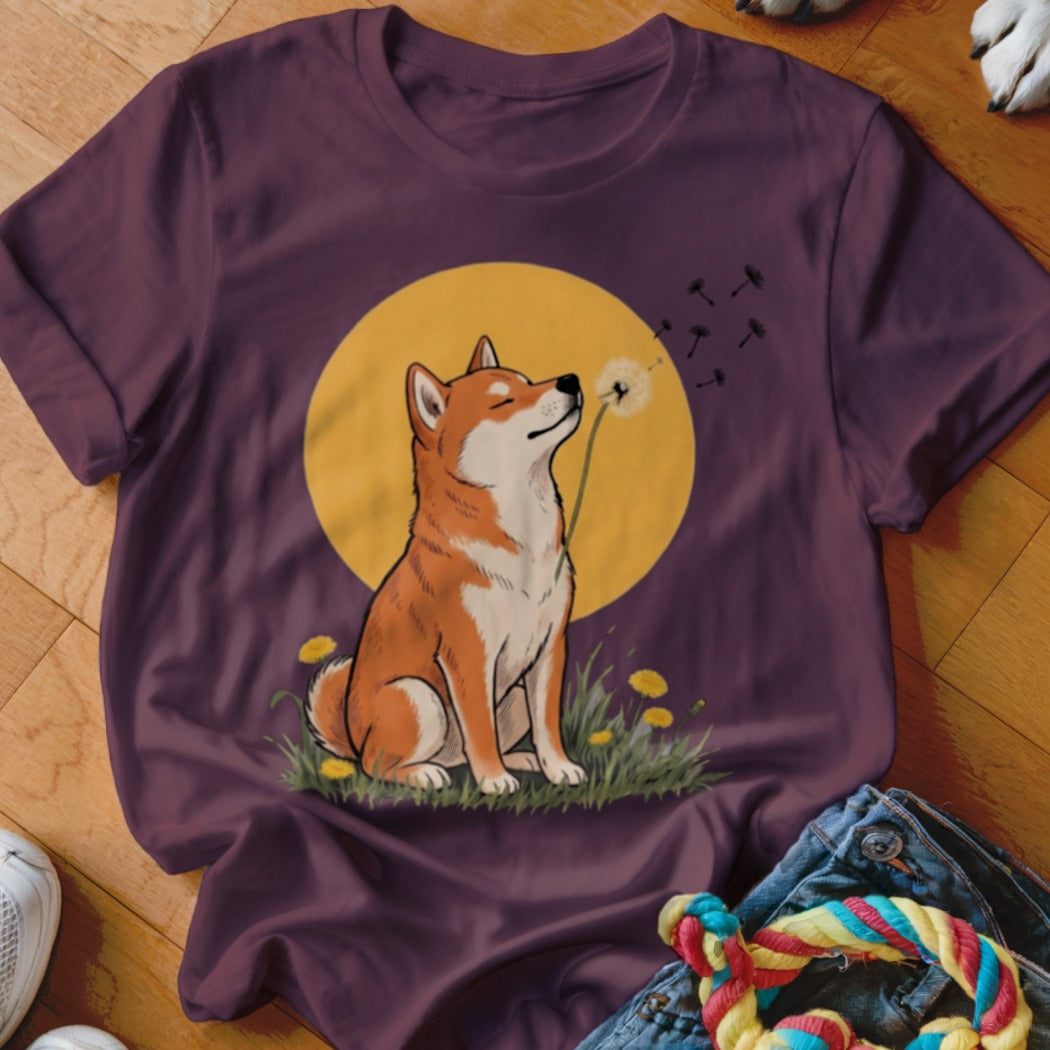 Maroon short-sleeved t-shirt featuring a graphic of a Shiba Inu dog sniffing a dandelion against a yellow circle background.