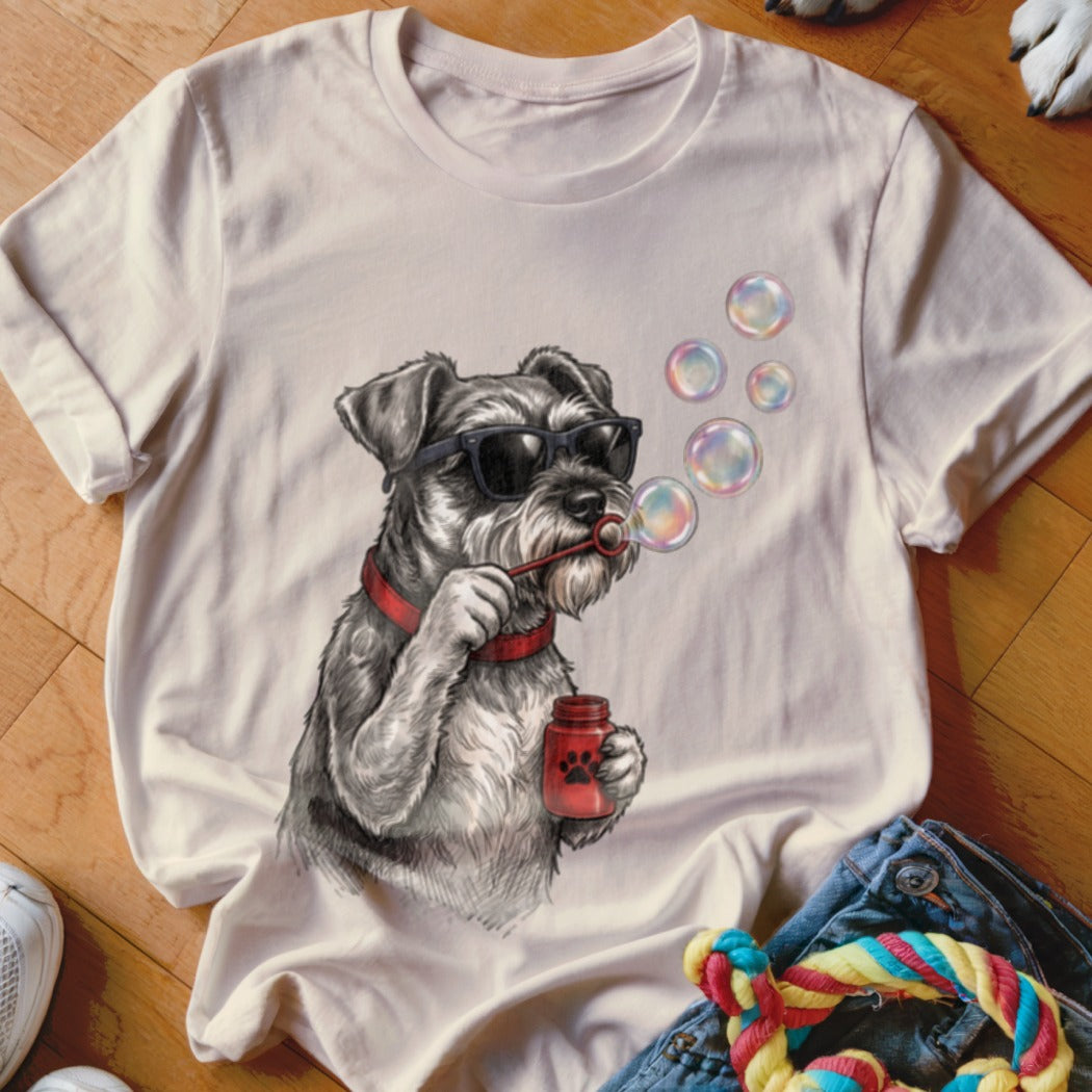 A light pink t-shirt printed with a graphic of a Schnauzer wearing sunglasses and blowing bubbles.