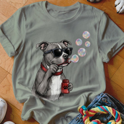 Sage green t-shirt featuring a graphic of a dog wearing sunglasses and blowing soap bubbles.
