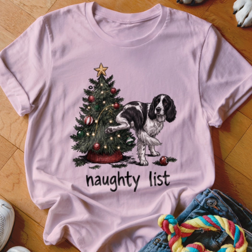 English Springer Spaniel marking a Christmas tree with "naughty list" text below.