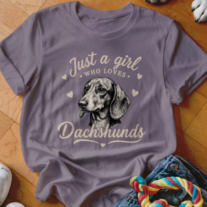 A grey t-shirt featuring a dachshund illustration and the text "Just a girl who loves Dachshunds."