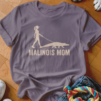 Graphic of person walking a crocodile on leash with text "MALINOIS MOM".