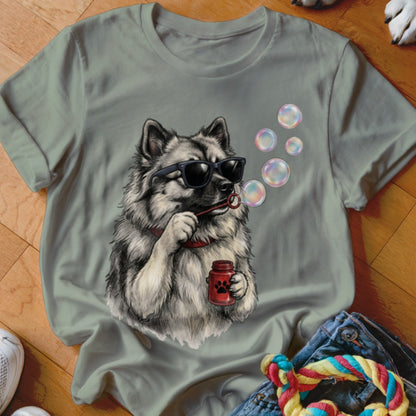 Sage green t-shirt featuring a graphic of a fluffy dog wearing sunglasses and blowing bubbles.