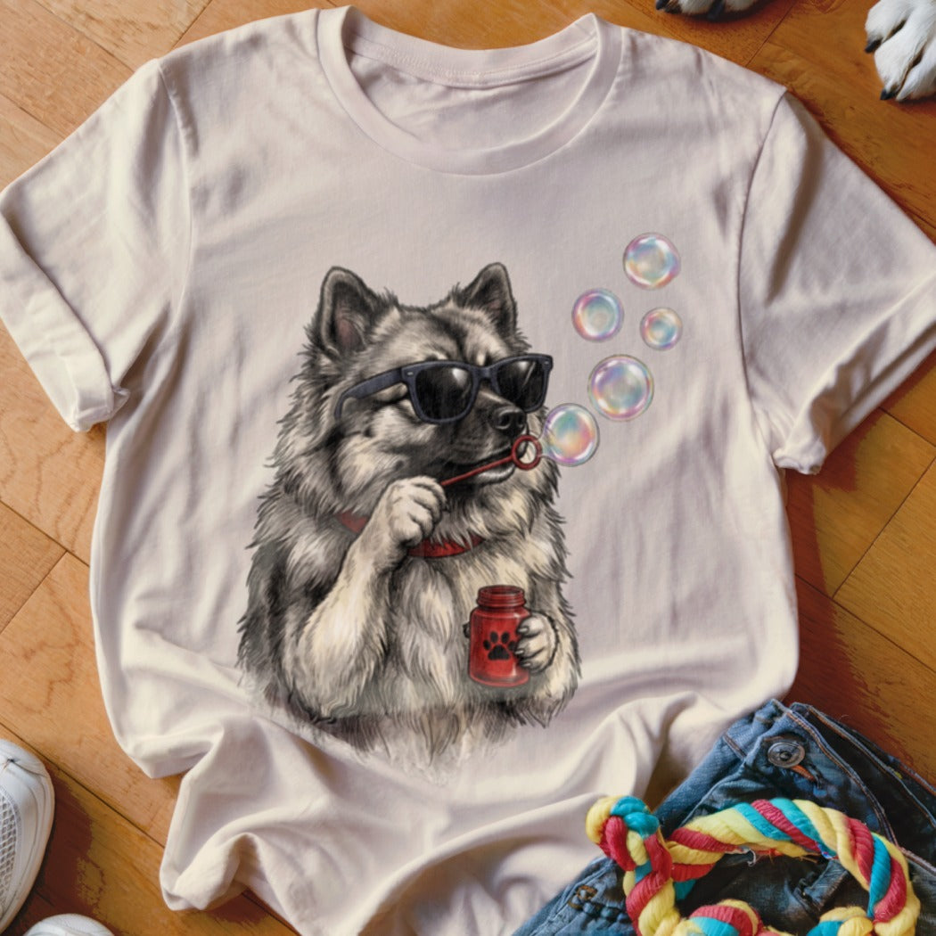 A light-colored t-shirt features a graphic of a fluffy dog wearing sunglasses and blowing bubbles.