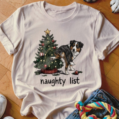 Australian Shepherd near Christmas tree with text "naughty list"