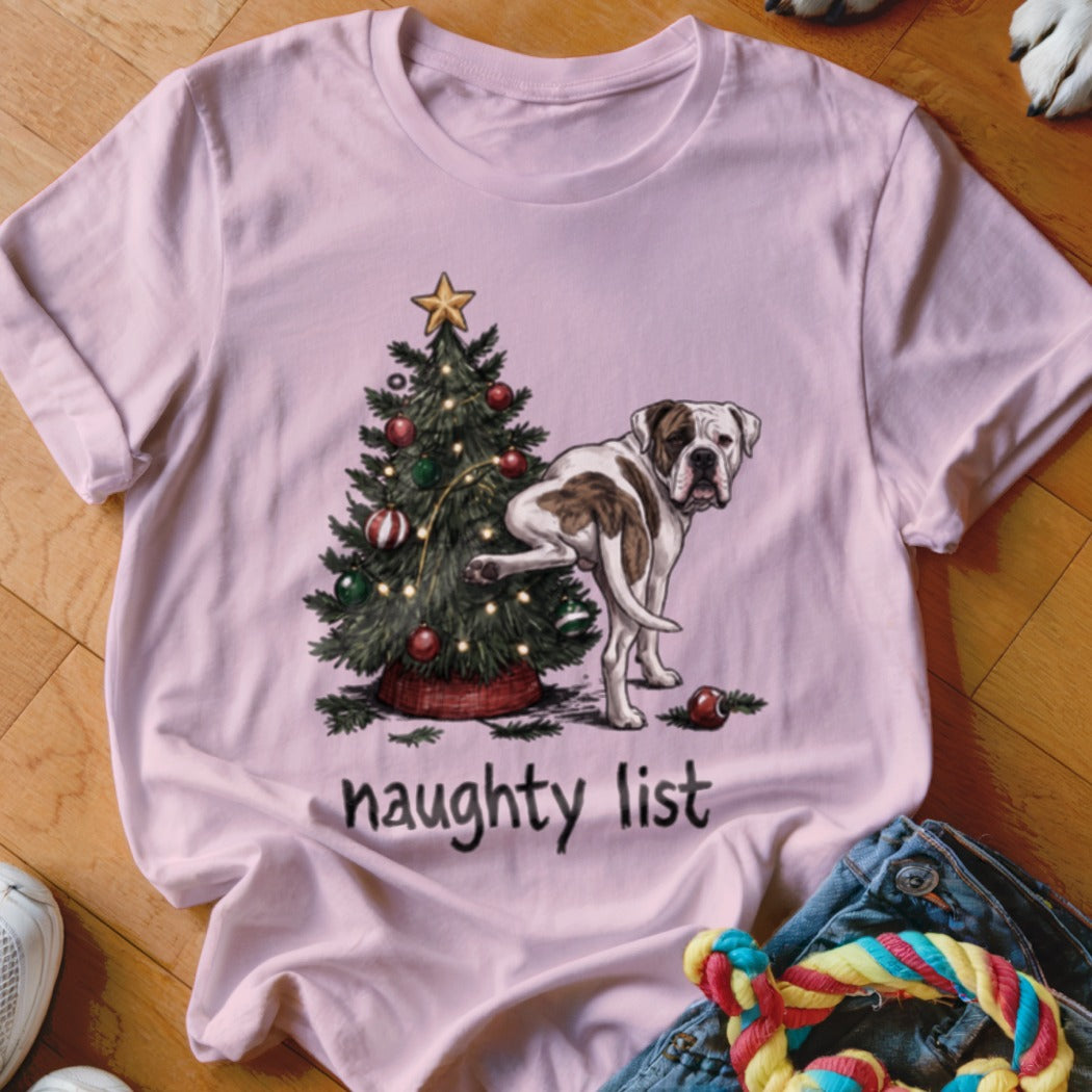 Bulldog peeing on Christmas tree with "naughty list" text on pink t-shirt.